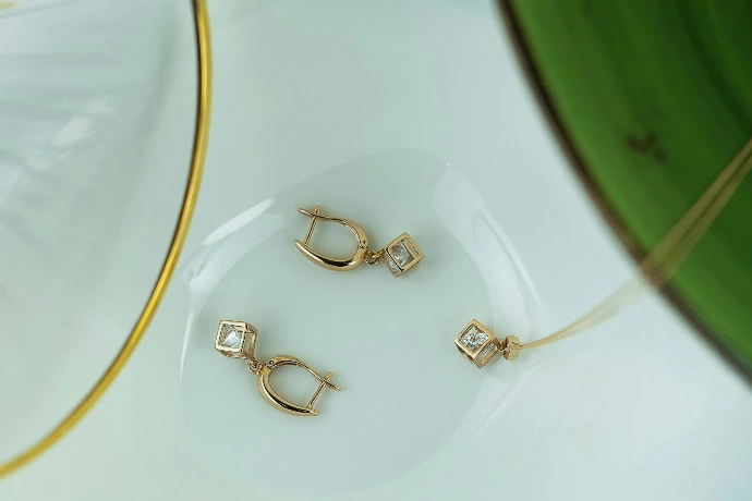 A close up of three pairs of earrings on a plate
